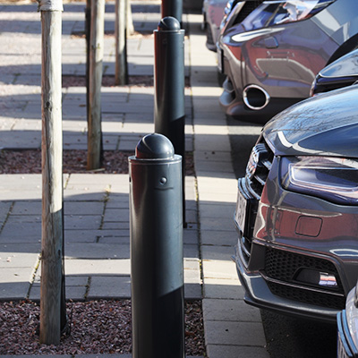 Close up of parking bollards, with a car parked behind them.